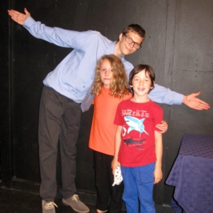 Three actors pose onstage together