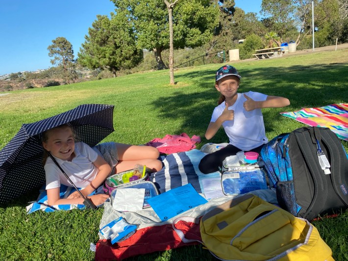 Two actors on lunch break pose for the camera outside