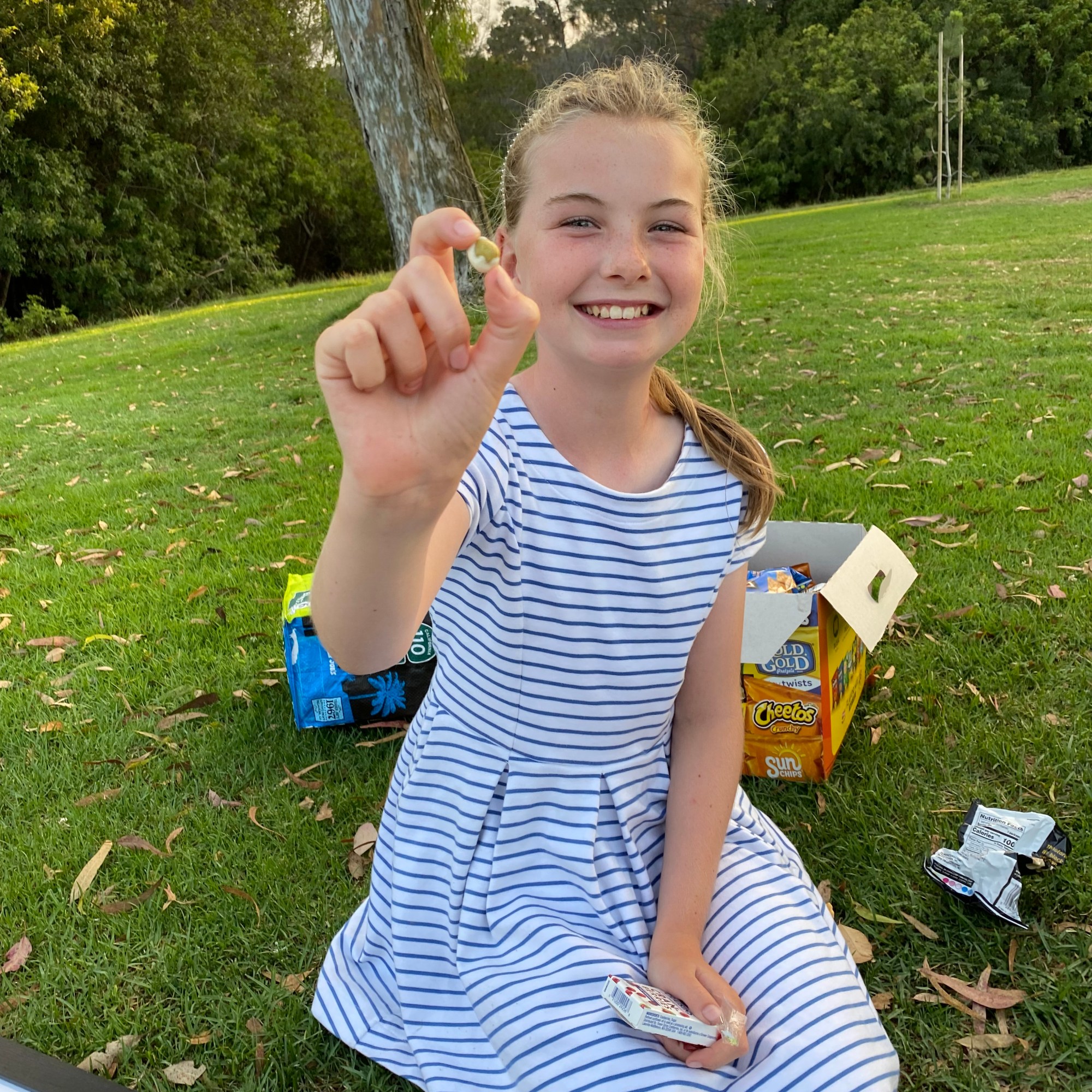 An actor on break holding up a wasabi pea to the camera